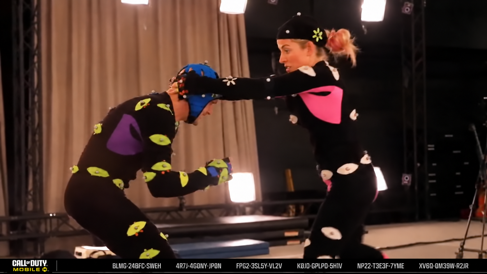 Two performers in motion-capture marker suits acting out a fight beat on a mocap stage for Call of Duty: Mobile